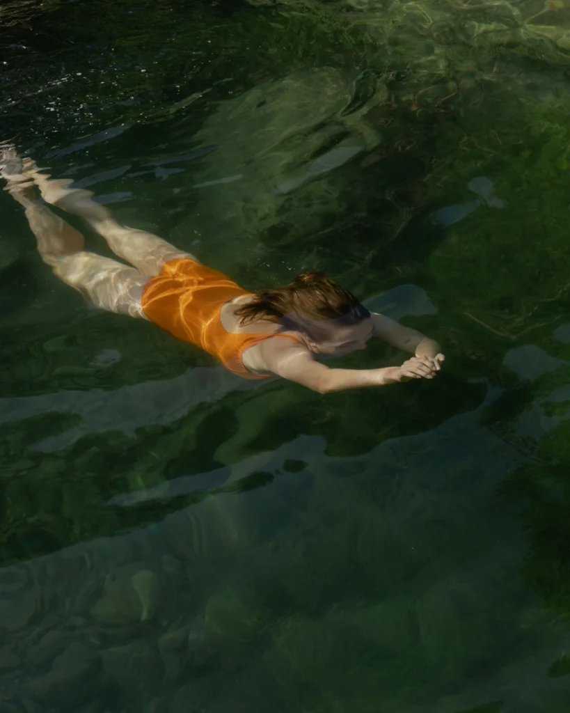 Woman swimming as part of self-love and wellness routine for mental health